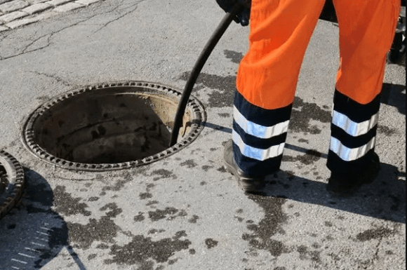 Image of a Workman unblocking a drain