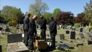 Picture of Pallbearers lowering a Coffin in to a Grave at a Funeral